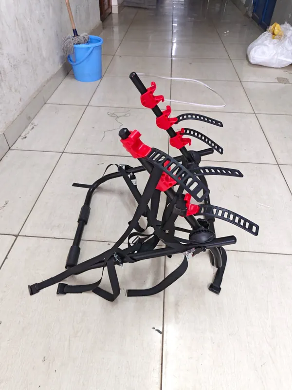 Bike carrier folded flat, with its straps and red bike holders
