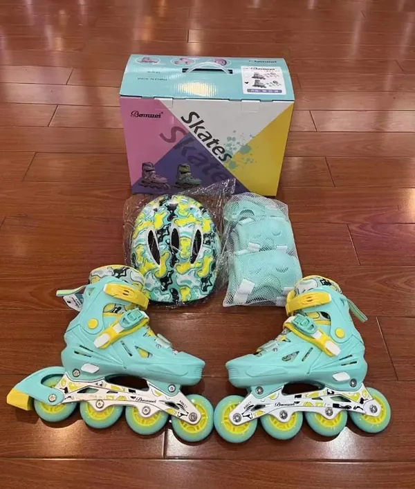 Green rubber-wheel inline skates full set with helmet and guards, in front of its box