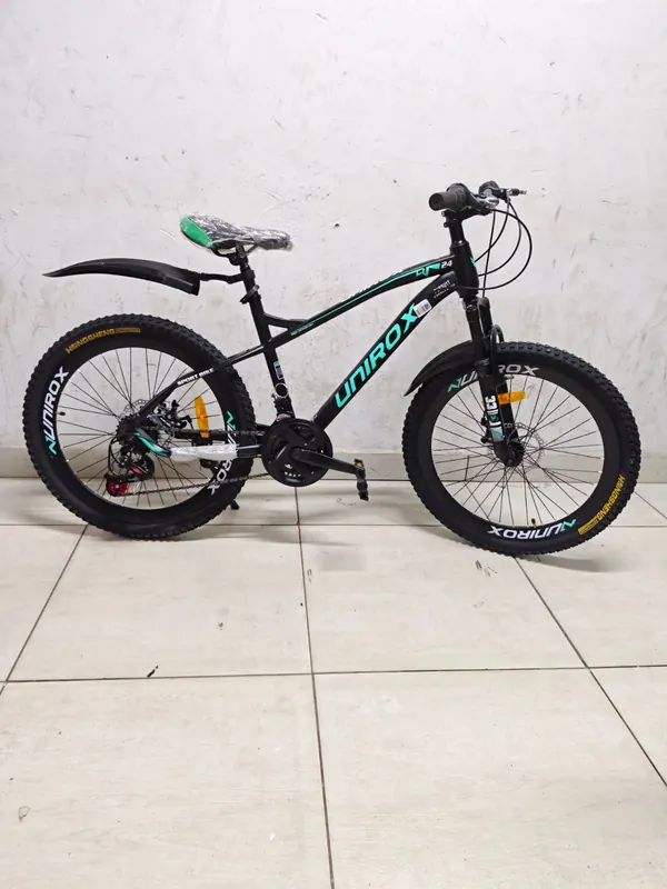 Unirox mountain bike in black with teal lettering, on its kickstand
